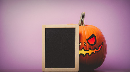 one orange pumpking and blackboard on purple backgroundの写真素材