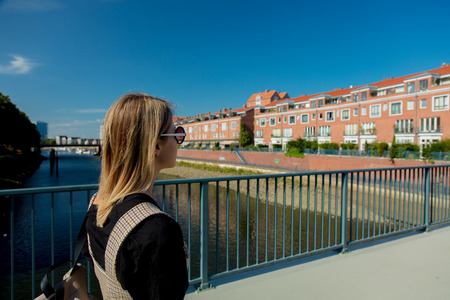 Young girl stay on a bridge with view at Bremen, Germany on backgroundの写真素材
