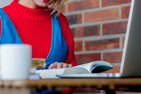 Young girl study with books and laptop computer at table.の写真素材