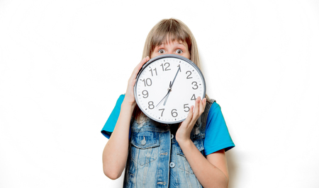 Portrait of young sad teenage girl with clock on white backgroundの写真素材