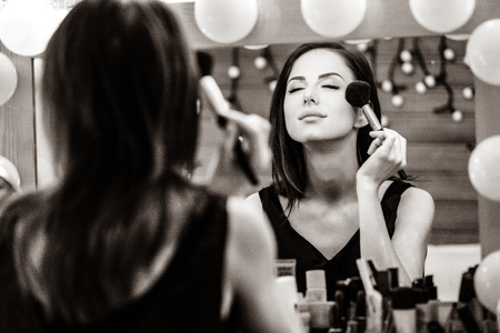 portrait of beautiful young woman doing makeup. Image in black and white color styleの写真素材