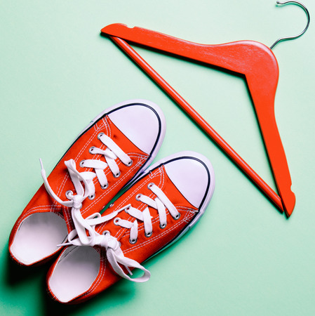 Red gumshoes and hanger on the green backgroundの写真素材