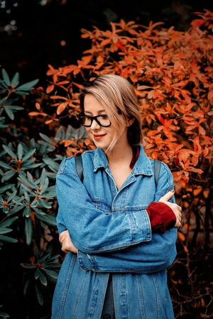 beautiful young girl in jacket in a park. Fall season time scene.の写真素材