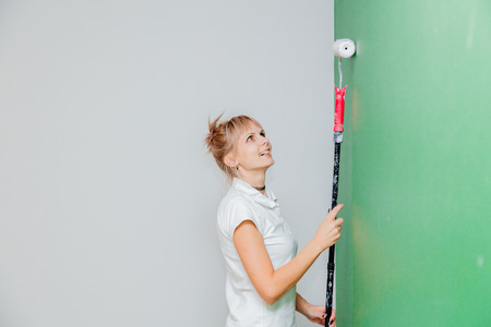 Young woman with paint roller in own house after painting a room. Real peopleの写真素材