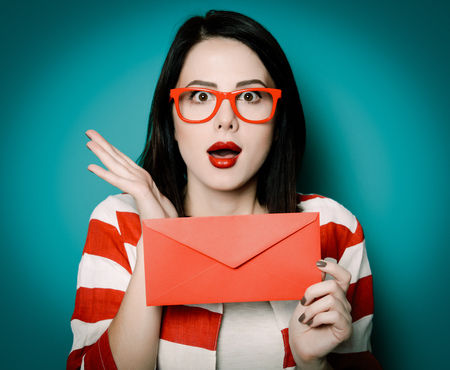 Brown hair girl with envelope on green background.