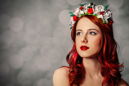 Beautiful redhead woman with wreath on gray backgroundの写真素材
