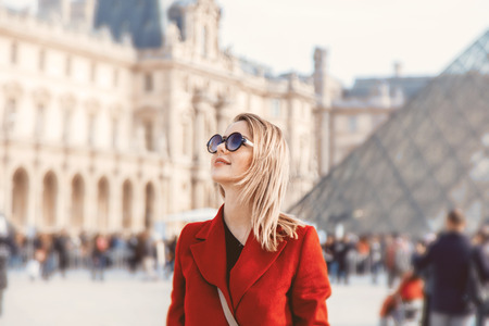 Style redhead girl in red coat and bag on parisian street in autumn season timeの写真素材