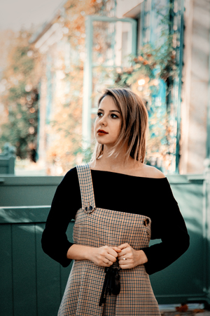 Young girl in dress and black clothes near house in Versailles, France. Autumn season time.の写真素材