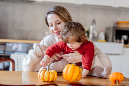 Mother and son have a fun with pumpkins at kitchen at home.の写真素材