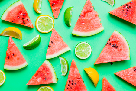 Above view at cutted lemons and limes with watermelon on green backgroundの写真素材