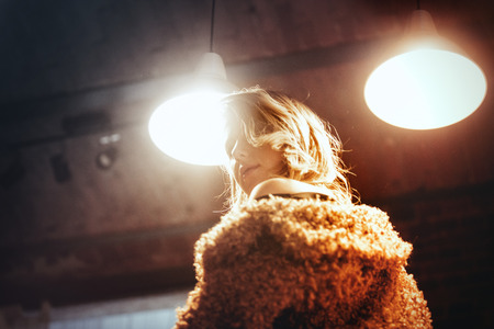 Style blond girl with makeup in coat stay at lamp backgroundの写真素材