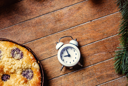 Christmas pie and little alarm clock on wooden table. Hight angle point of viewの写真素材