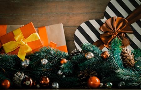 Gift box with pine cones and branches on wooden background. Image with Christmas holiday themeの写真素材