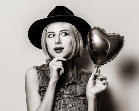 Portrait of young style hipster girl with heart shape balloon. St. Valentines Day . Image in black and white color style.の写真素材