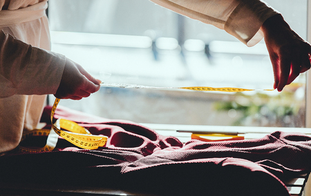 Fashion designer hands with dress and measure tape. Side viewの写真素材