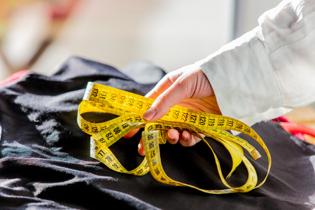 Fashion designer hands with dress and measure tape. Side viewの写真素材