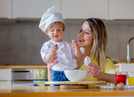 mother and child boy painting eggs for Easter Holiday at home at kitchen.の写真素材