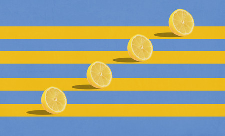 Group of lemons in air on blue background with yellow stripes. Side viewの写真素材