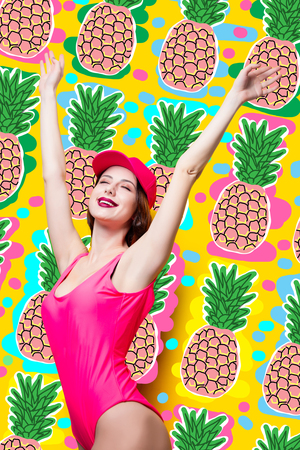 Elegant brunette woman in pink swimsuit and fashion cap. Sexy lady in pink beachwear, enjoying sun on yellow summer backgroundの写真素材