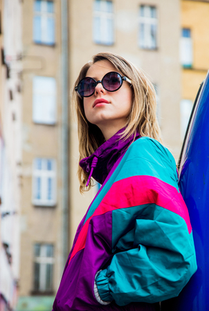 Young woman in jacket of 90s style stay at counrtyard of house in East Europeの写真素材