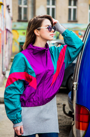 Young woman in jacket of 90s style stay at counrtyard of house in East Europeの写真素材