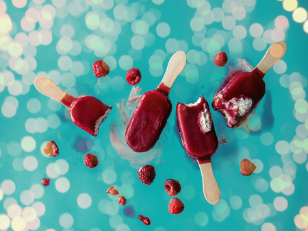 raspberries ice lolly in air on blue background. Object without shadowsの写真素材