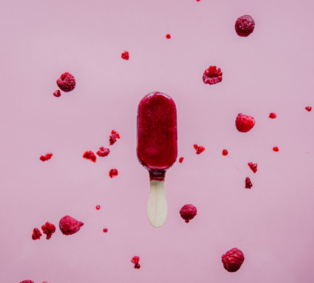 raspberries ice lolly in air on pink background. Object without shadowsの写真素材