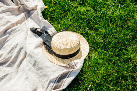 Cloth and hat on picnic on meadow. Spring time season