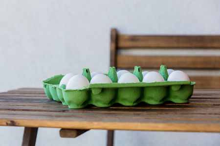 Chicken eggs in box on a wooden table at home.の写真素材