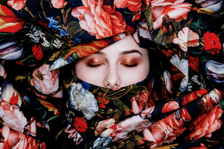 Portrait of a young girl with red lipstick shrouded flower fabric