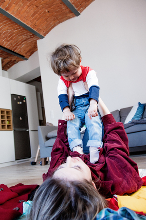 Mother and son playing on a floor at home.の写真素材