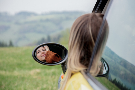 Woman sitting in a little car on a driver place. Located in a mountains.の写真素材