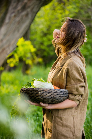Young woman with apple and vegetable basketの写真素材