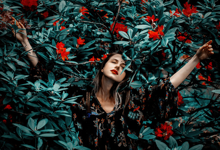 Style woman near rhododendron flowers in a garden in spring timeの写真素材