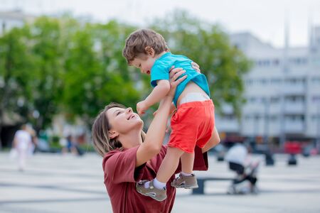 little toddler boy and mother have a fun on the city streetの写真素材