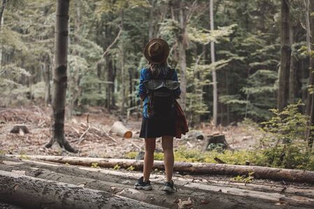 Style girl in hat with backpack in a summer time Mixed coniferous forestの写真素材