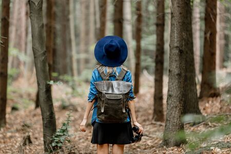 Young woman with binocular and backpack in a forestの写真素材