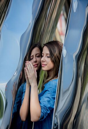young woman stay near metal construction with reflection