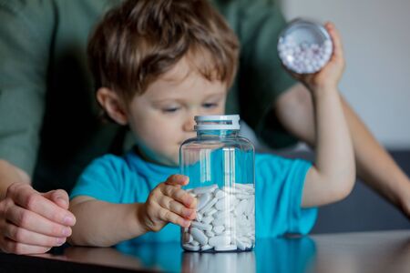 Mother and child holding two jars of pillsの写真素材