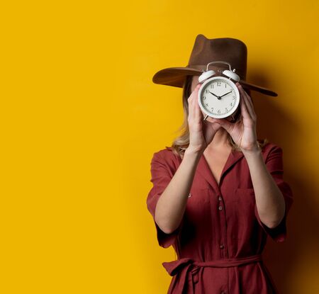 Woman in 1940s style clothes with alarm clockの写真素材