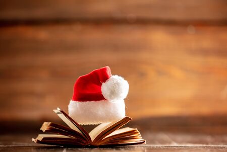 Christmas hat and open book on wooden tableの写真素材
