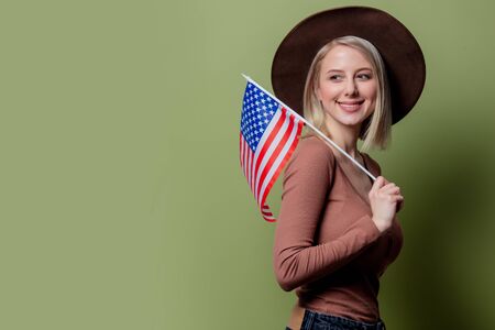 Beautiful cowgirl in a hat with United States of America flagの写真素材