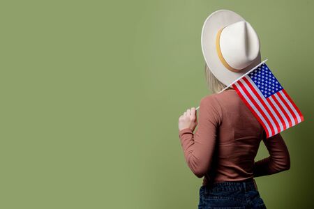 Beautiful cowgirl in a hat with United States of America flagの写真素材