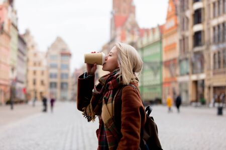 Beautiful blonde woman drink a coffee in old town