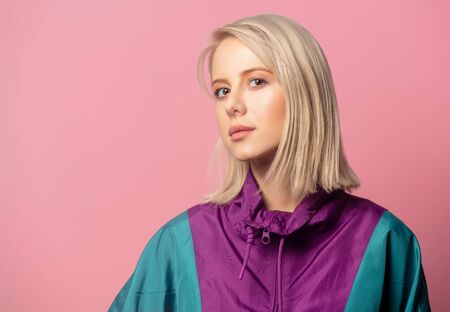 Beautiful blonde woman in 90s clothes style on pink background
