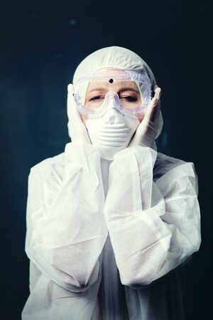 medic woman wearing protective clothing against the virus on dark background