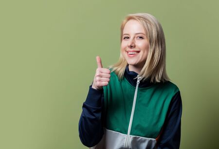Style blonde woman in 80s clothes on green background