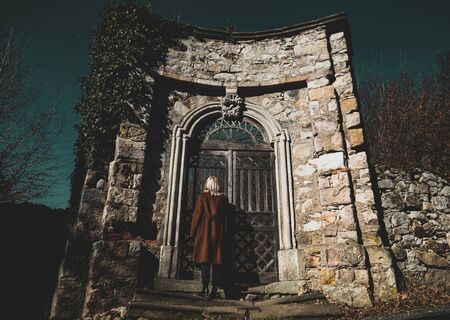 Blonde woman near ruins of old door in a castle in South Poland