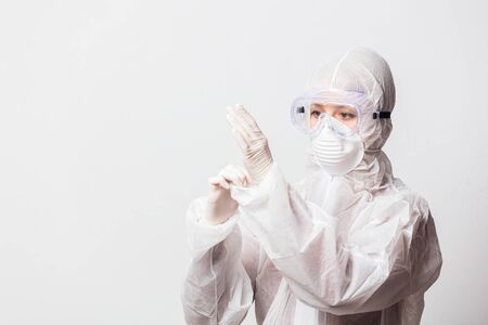 young doctor in protection suit and glasses with mask on white backgroundの写真素材