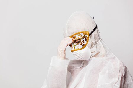 female doctor in protection suit and glasses with  carnival maskの写真素材